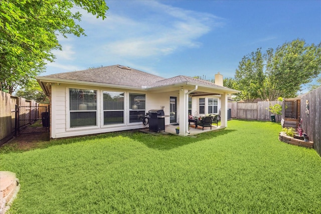 back of house featuring a lawn, a fenced backyard, a chimney, and a patio
