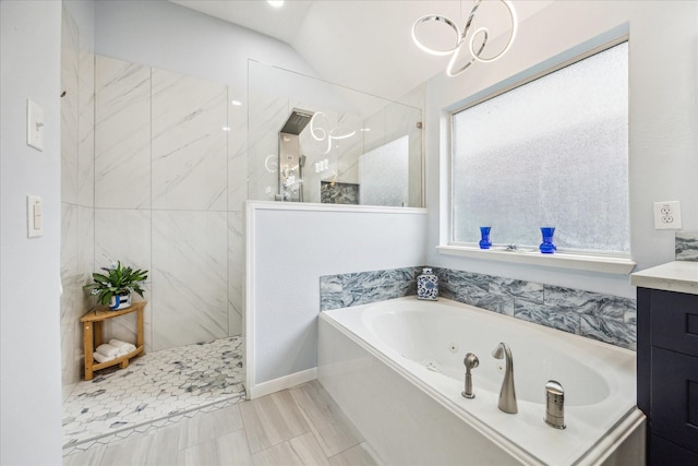 bathroom with a tub with jets, walk in shower, a chandelier, and vanity