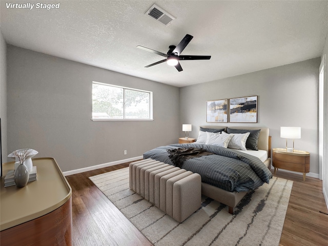 bedroom featuring visible vents, baseboards, and wood finished floors