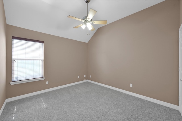 spare room with carpet floors, baseboards, ceiling fan, and vaulted ceiling