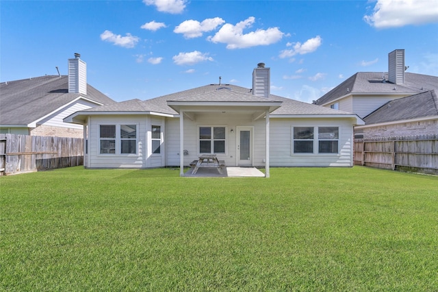 back of property with a patio, a fenced backyard, a lawn, and roof with shingles