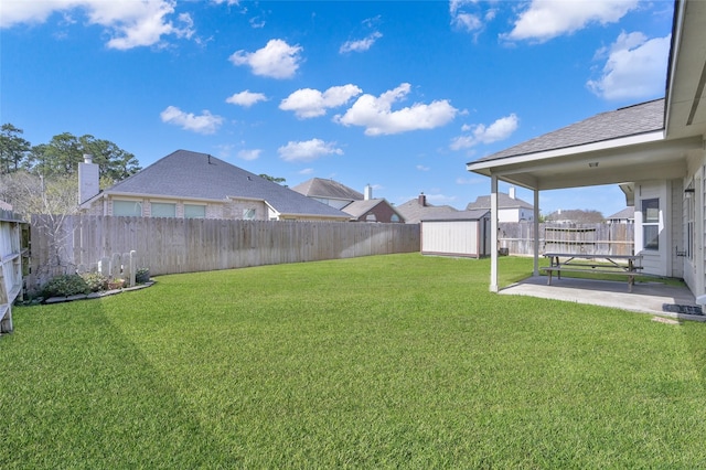 view of yard featuring a fenced backyard, an outbuilding, a shed, and a patio