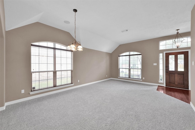 entryway featuring carpet flooring, a notable chandelier, visible vents, baseboards, and vaulted ceiling