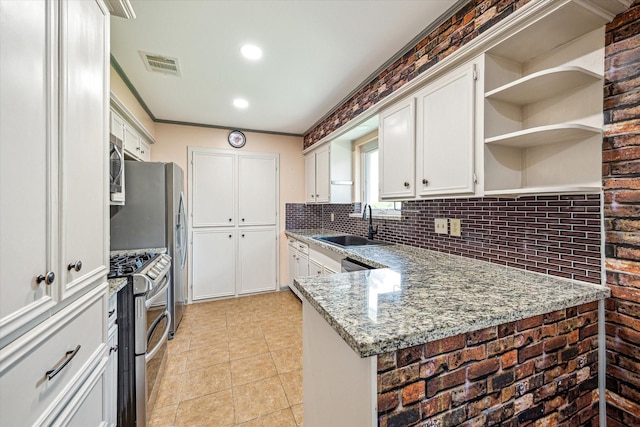 kitchen featuring visible vents, decorative backsplash, white cabinetry, a sink, and stainless steel appliances