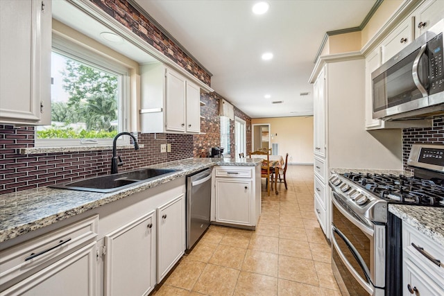 kitchen with a sink, tasteful backsplash, and stainless steel appliances