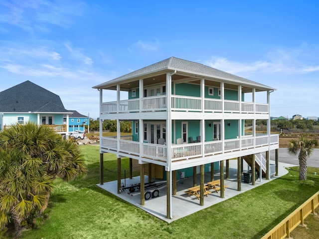 4014 Miramar Ct, Galveston, TX 77554 - back of property featuring a patio, a shingled roof, a balcony, and a yard