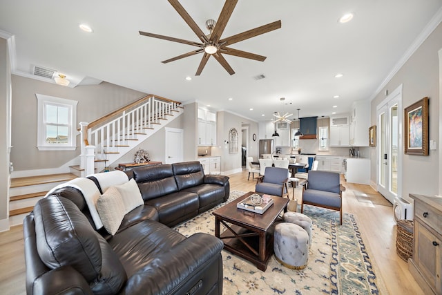 4014 Miramar Ct, Galveston, TX 77554 - living area featuring stairs, ceiling fan with notable chandelier, and light wood-style floors