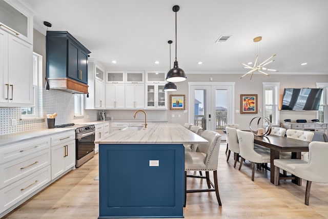 4014 Miramar Ct, Galveston, TX 77554 - kitchen with visible vents, decorative backsplash, a sink, a kitchen island with sink, and electric stove