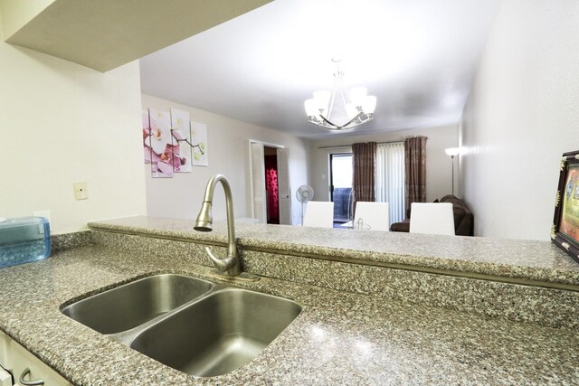 kitchen featuring a sink, hanging light fixtures, and a chandelier