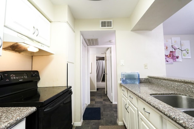 kitchen featuring under cabinet range hood, black range with electric cooktop, white cabinetry, and visible vents