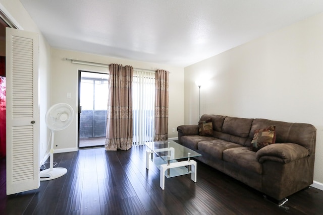 living area with baseboards and dark wood-style floors