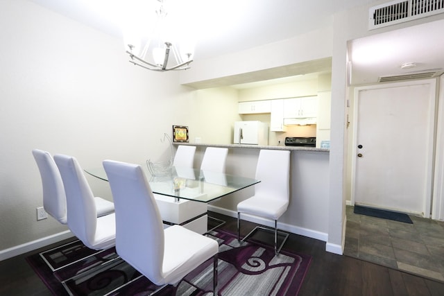 dining space with baseboards, a notable chandelier, visible vents, and dark wood finished floors