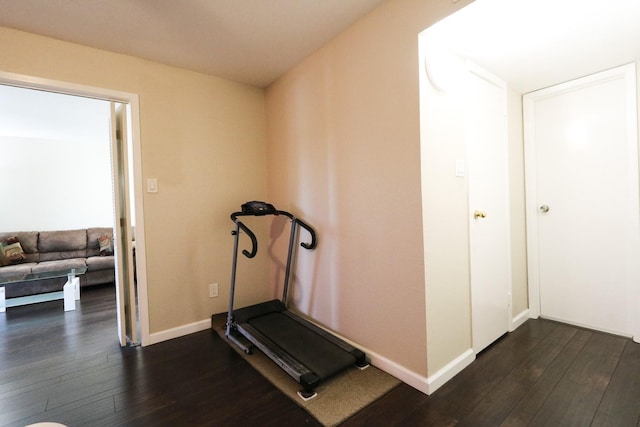 exercise room featuring baseboards and dark wood-style floors