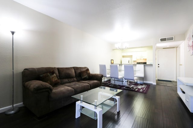 living area featuring baseboards, dark wood-style flooring, a chandelier, and visible vents