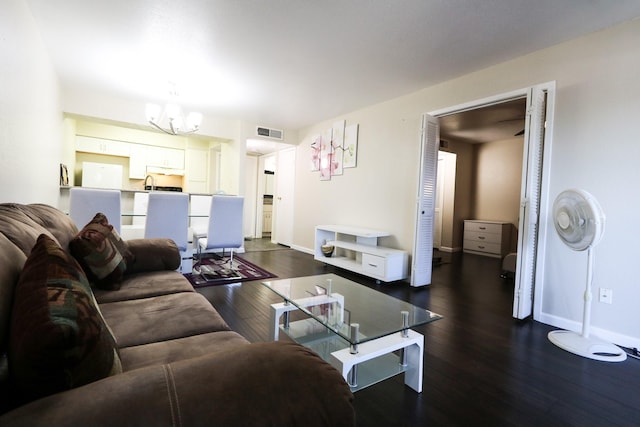 living room featuring dark wood-style flooring, baseboards, an inviting chandelier, and visible vents