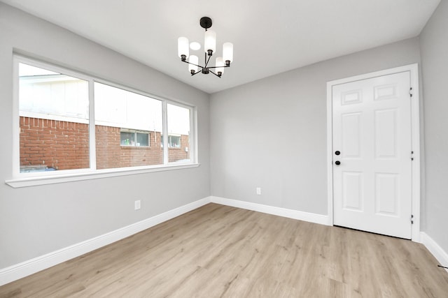 16315 Summer Dew Ln, Houston, TX 77095 - empty room with a chandelier, light wood-style flooring, and baseboards