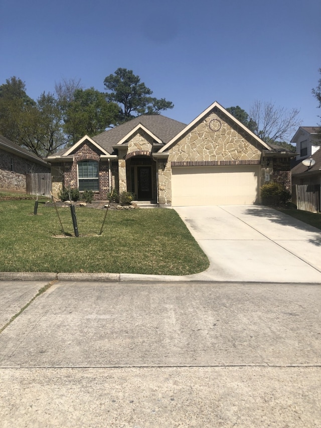 ranch-style house featuring driveway, fence, a front lawn, an attached garage, and stone siding