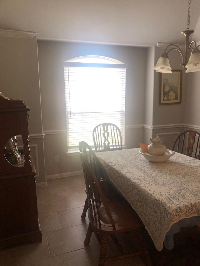 tiled dining room with an inviting chandelier