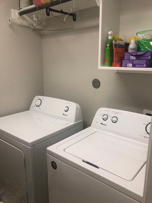 clothes washing area featuring separate washer and dryer and laundry area