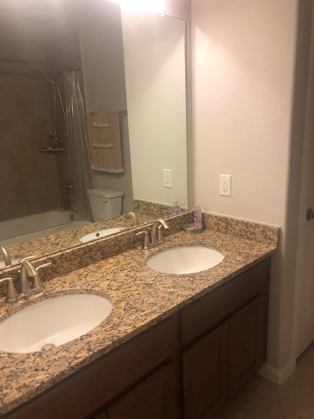 bathroom featuring double vanity, a sink, and shower / bath combo