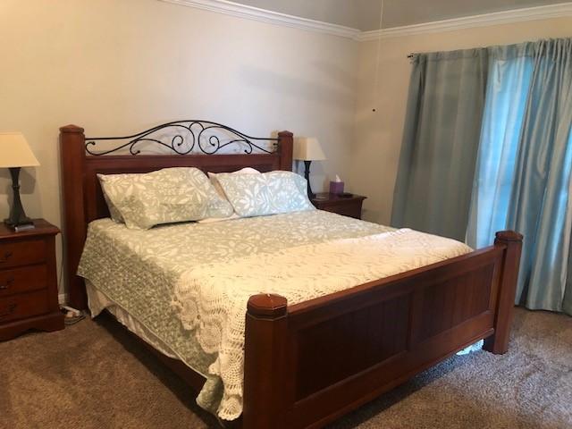 bedroom featuring crown molding and carpet flooring