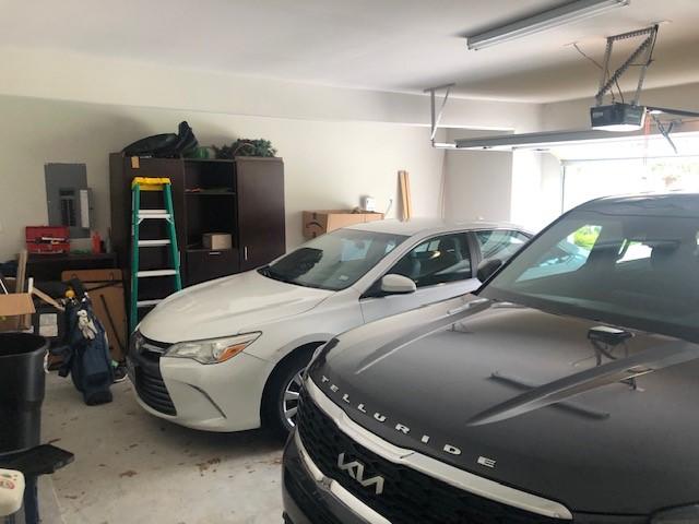 garage with a garage door opener and electric panel