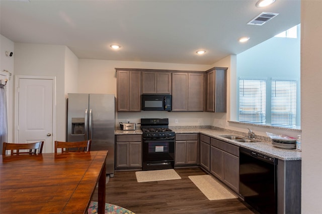 kitchen with visible vents, a sink, black appliances, dark wood-style floors, and recessed lighting