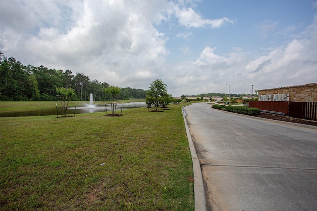 view of street with a water view and curbs