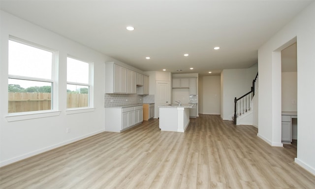 4439 Azalea Blossom Rd, Pinehurst, TX 77362 - kitchen featuring open floor plan, a center island with sink, light wood-type flooring, recessed lighting, and a sink