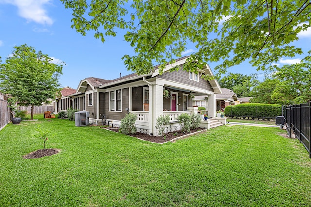 view of side of home featuring a lawn, a fenced backyard, central air condition unit, and covered porch