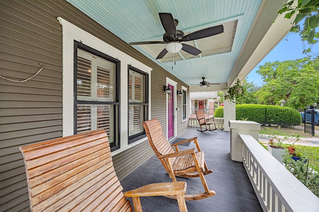 wooden terrace with fence, covered porch, and ceiling fan