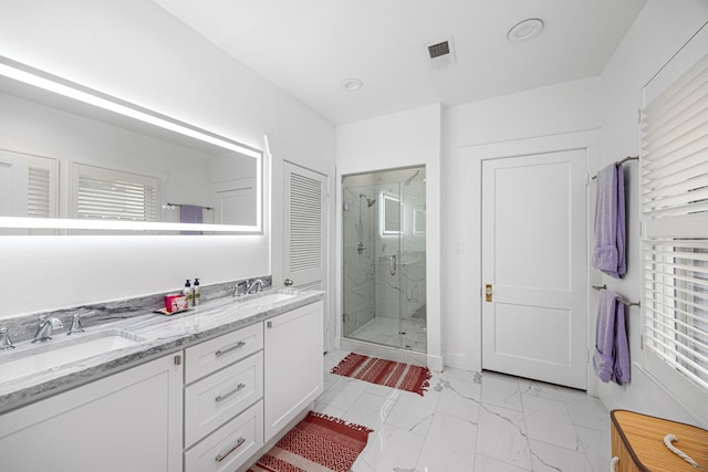 bathroom featuring visible vents, double vanity, marble finish floor, a shower stall, and a sink