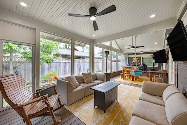 sunroom / solarium with wood-type flooring, ceiling fan, and an outdoor living space