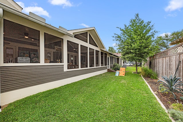 view of yard with fence and a sunroom