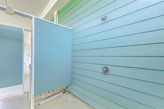 exterior space featuring wood walls and concrete floors