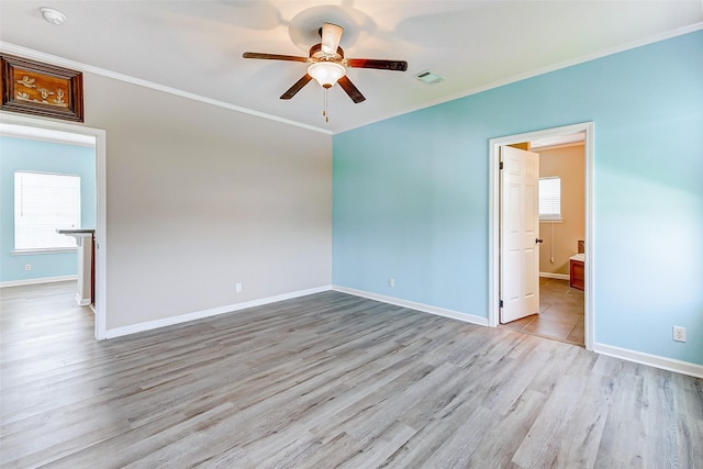 unfurnished room with visible vents, crown molding, baseboards, a ceiling fan, and light wood finished floors