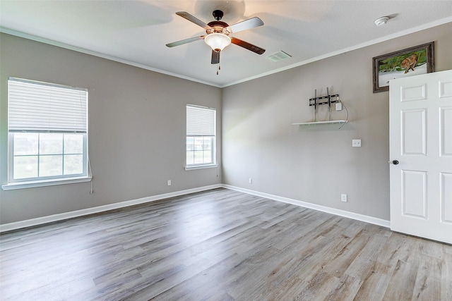 unfurnished room with a ceiling fan, visible vents, ornamental molding, and wood finished floors