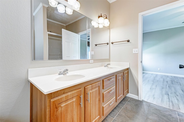 full bathroom featuring crown molding, double vanity, baseboards, and a sink