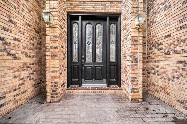 property entrance with brick siding and french doors