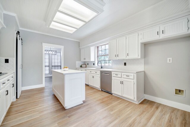 kitchen featuring a kitchen island, stainless steel dishwasher, backsplash, and ornamental molding