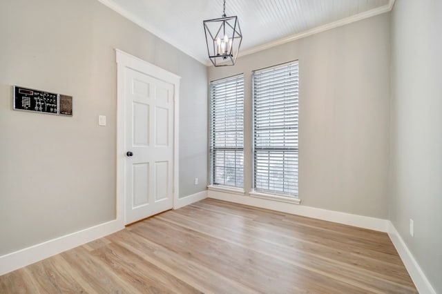 unfurnished dining area with crown molding, a chandelier, a healthy amount of sunlight, and light wood finished floors