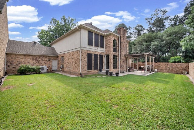 back of property with a pergola, a chimney, brick siding, a patio area, and a lawn
