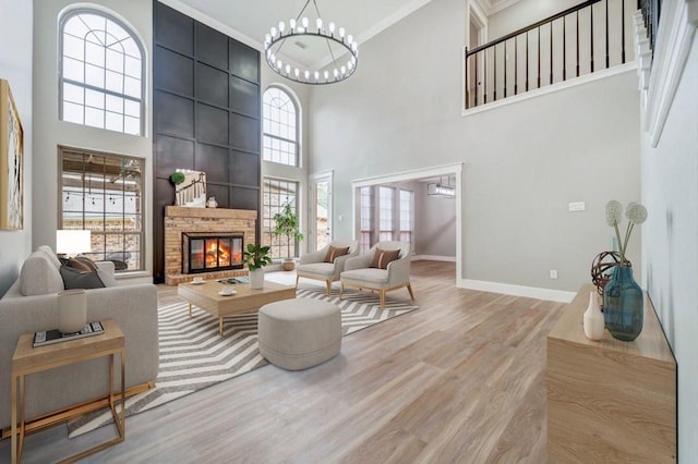 living area featuring baseboards, a high ceiling, and a fireplace