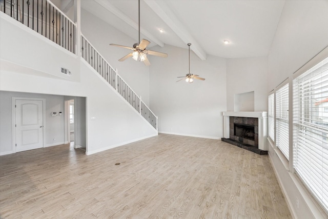 138 Isles End Rd, Tiki Island, TX 77554 - unfurnished living room featuring a ceiling fan, a tile fireplace, a towering ceiling, light wood-type flooring, and beam ceiling