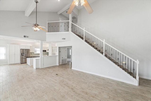 138 Isles End Rd, Tiki Island, TX 77554 - unfurnished living room featuring a ceiling fan, stairway, beamed ceiling, light wood finished floors, and high vaulted ceiling
