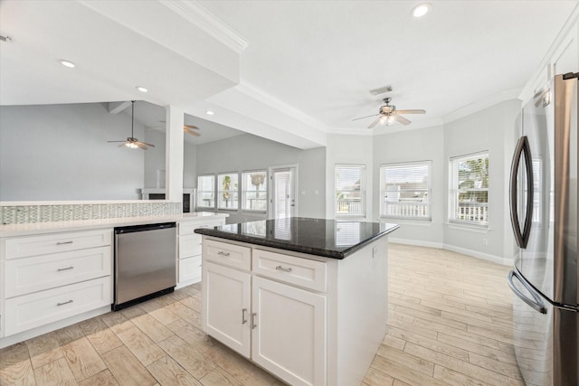 138 Isles End Rd, Tiki Island, TX 77554 - kitchen with appliances with stainless steel finishes, a ceiling fan, ornamental molding, healthy amount of natural light, and light wood-type flooring