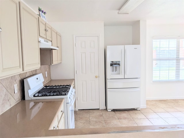 kitchen with decorative backsplash, white appliances, under cabinet range hood, cream cabinets, and light tile patterned floors