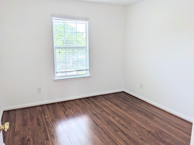 unfurnished room featuring a healthy amount of sunlight, baseboards, and wood finished floors