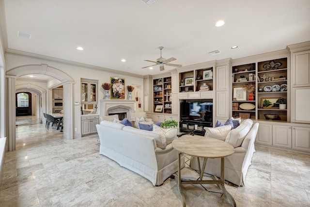 living area with a ceiling fan, arched walkways, recessed lighting, and ornamental molding