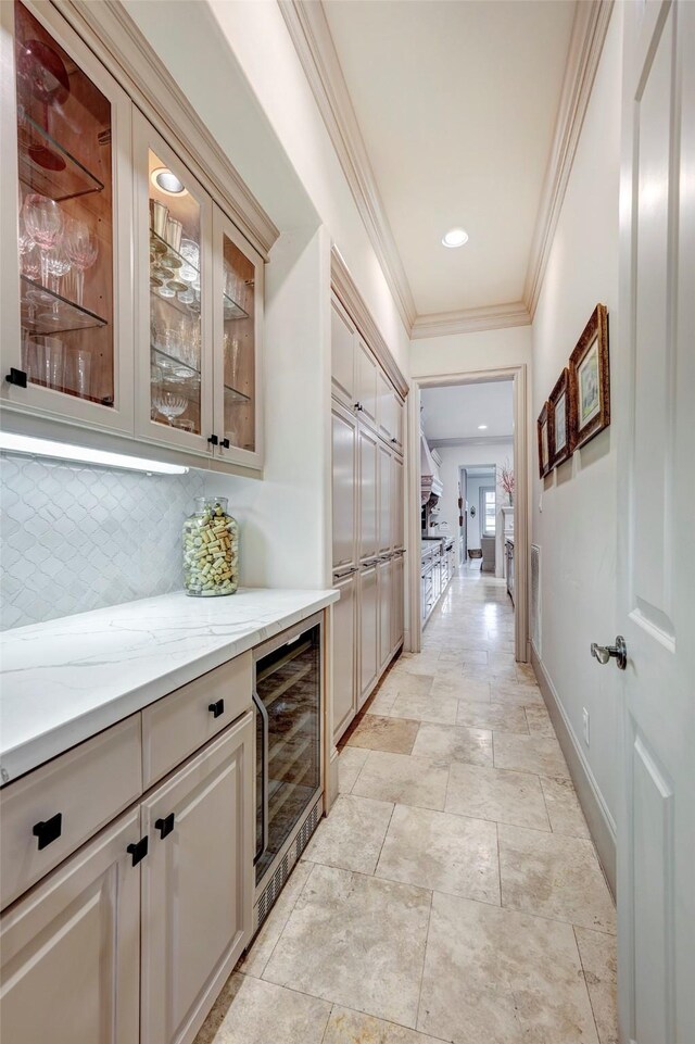 hall featuring crown molding, baseboards, and wine cooler